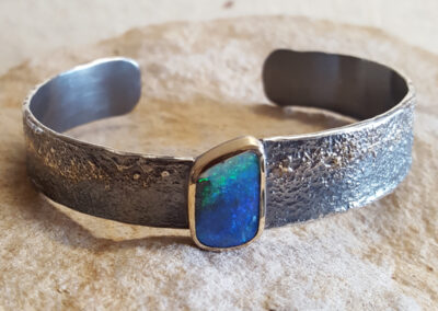 Armspange aus geschwärztem Silber und 750/- Gelbgold mit einem australischen Boulder-Opal