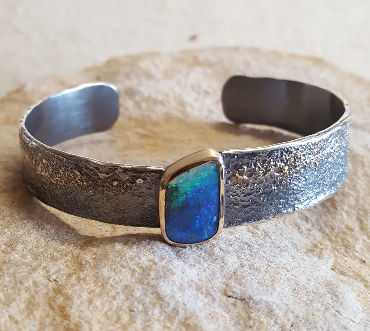 Armspange aus geschwärztem Silber und 750/- Gelbgold mit einem australischen Boulder-Opal