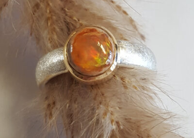 Ring aus Silber eismatt mit einem Feueropal in Fassung aus 750/- Gelbgold